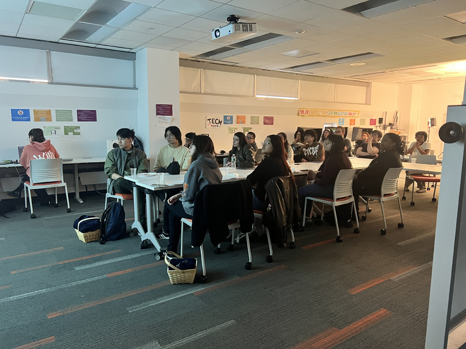 Students sitting at tables in the NMA Studio.