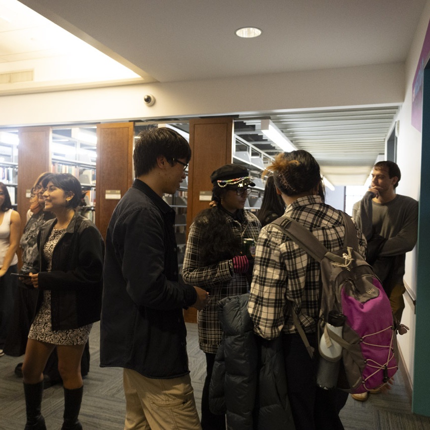 Students stand in groups talking casually.