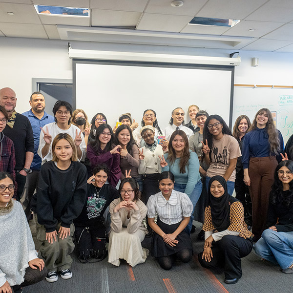 Students and faculty posing for a group photo in front of the NMA Studio.